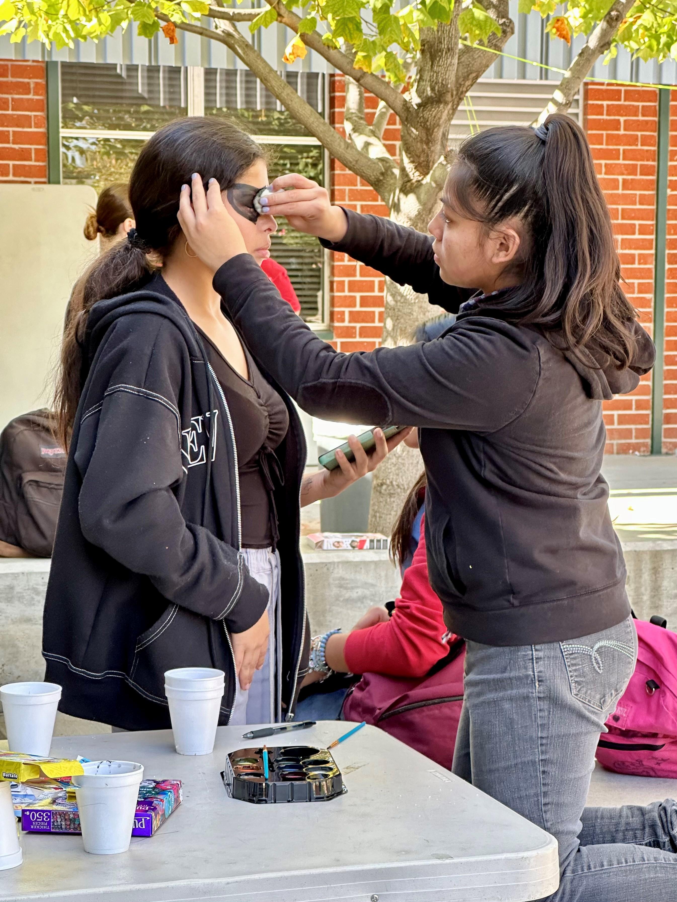 Students at Fremont face paint traditional mexican patterns to celebrate holiday